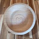 Wooden bowl with a engraved design of a cat on a wooden surface