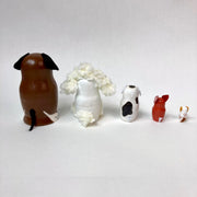 Set of 5 nesting dolls, shaped like dogs. Each breed is different and painted accordingly. Back view to show their various tails.