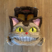 Catbus shaped paper mache and fur wall hanging sculpture, smiling and with lighting elements.