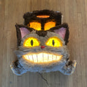 Catbus shaped paper mache and fur wall hanging sculpture, smiling and with lighting elements.