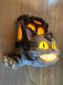 Catbus shaped paper mache and fur wall hanging sculpture, smiling and with lighting elements.