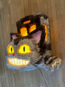 Catbus shaped paper mache and fur wall hanging sculpture, smiling and with lighting elements.