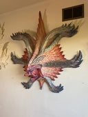 Decorative wall art of a monster creature's face on a plain wall.