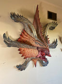 Decorative wall art of a monster creature's face on a plain wall.