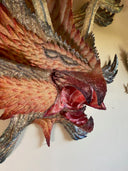 Decorative wall art of a monster creature's face on a plain wall.