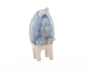 Ceramic sculpture of a small blue and white creature with small ears and eyes and no arms but 4 legs.