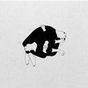2 figures in black clothes, formed into a ball and leaning against one another.