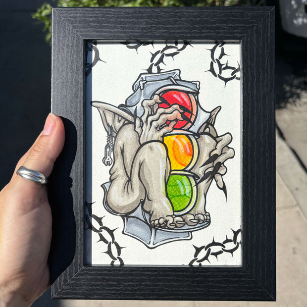 Framed artwork of a gargoyle with a traffic light on a white background