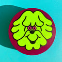 Panting of a neon green, stylized cartoon dog with fluffy hair and bright pink eyes. It is on a circular wooden panel with a burgundy background.