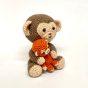 Two crocheted monkey toys, one larger and one smaller, on a white background.