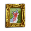 A small framed artwork featuring a whimsical illustration of a blue-gray cat with a pinkish-red abstract shape over a green background, set in an ornate gold frame on a white background.