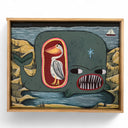 Framed artwork of a whale with a large mouth with many pointed teeth. The inside of it can be seen, holding a pelican.