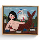 Framed illustration of a mermaid with a plaid tail and a stork, on her arm. She is very large in a tiny town, the buildings the size of her hand.
