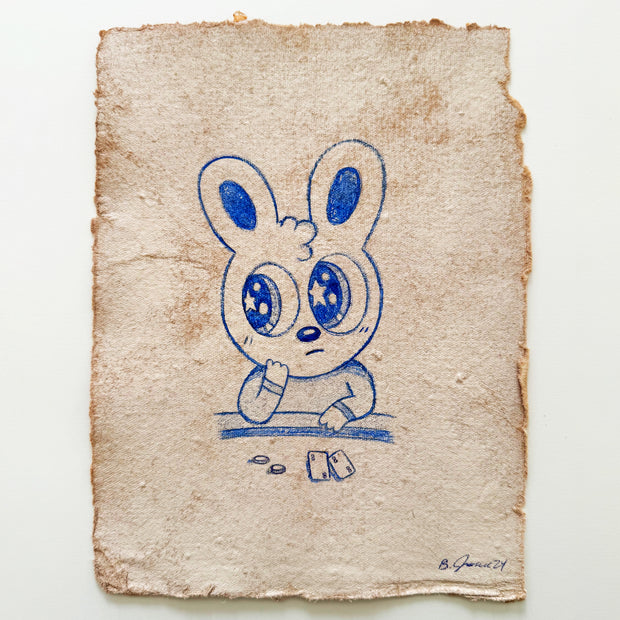 Blue color pencil drawing of a cartoon bunny sitting at a card table.