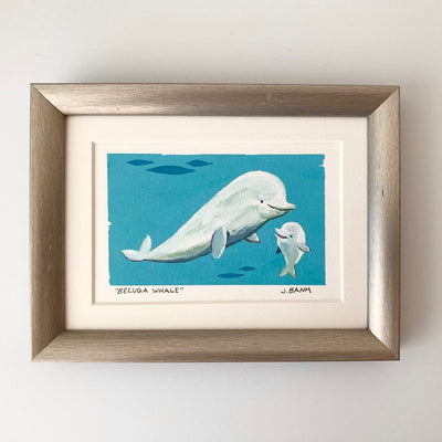 Painting on paper of an underwater scene of a large smiling beluga whale, looking down at a smaller beluga whale who looks up and smiles. Framed in a silver frame.