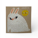 Illustration on brown paper of a white bunny smiling with a tiny sun in the background.