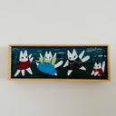 Framed artwork of four cartoon-style cats in colorful outfits on a white background
