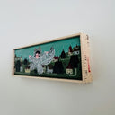 Framed artwork with a stylized illustration of a woman in a furry wolf costume, standing over a cityscape background and menacingly walking through it.