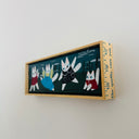 Painting of cartoon cats in colorful outfits, framed in a yardstick frame.