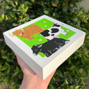 Illustrations of a brown bull, black and white cow, and black cow on a green background with flowers.