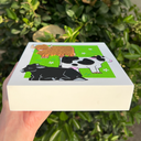 Illustrations of a brown bull, black and white cow, and black cow on a green background with flowers.