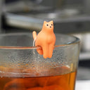 Orange cat-shaped object on a glass of tea with a blurred background