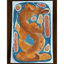 A stylized painting of a fox-like animal in warm orange-brown tones on a blue background, surrounded by abstract red and cream shapes, photographed against a dark wood surface.