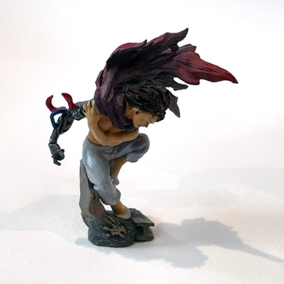 Vinyl figure of Tetsuo from Akira, shirtless and positioned on a slab of concrete. One arm is robotic and his red cape blows fiercely over his shoulder.