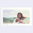 Woman sitting in a field with a scenic background