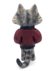 Sculpture of a cartoon gray cat, with closed eyes and a calm expression. It stands like a human and wears a burgundy jacket with its hands in its pockets.