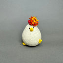 Ceramic figurine of a small white chicken with an opening at the top of its head for flowers.