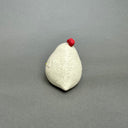 Ceramic figurine of a small white chicken with an opening at the top of its head for flowers.