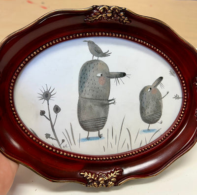 Illustration of 2 gray cartoon moles, walking on hind legs and with their arms extended out. A bird sits atop one of the mole's head.