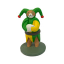 Gif of a sculpture of a cat dressed as a jester in a green and yellow outfit. 