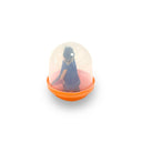 Small transparent capsule with a character inside on an orange base against a white background