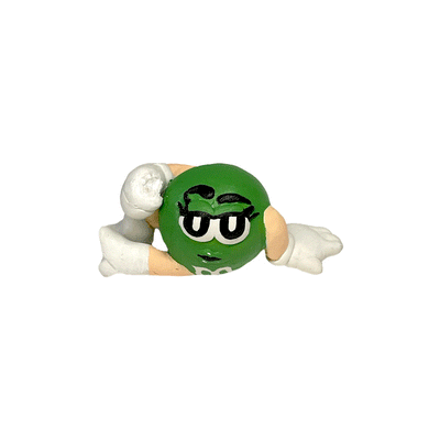 Gif of a sculpture of the Green M&M, lounging on the ground with one of her legs positioned up.
