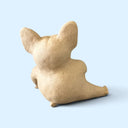 A small beige ceramic figurine shaped like a seated French bulldog, shown from the back against a solid light blue background.