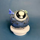 Ceramic sculpture of a small, blowfish with very very large eyes. It is blue with blue fins and green lips.