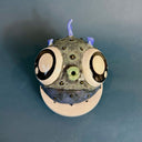 Ceramic sculpture of a small, blowfish with very very large eyes. It is blue with blue fins and green lips.