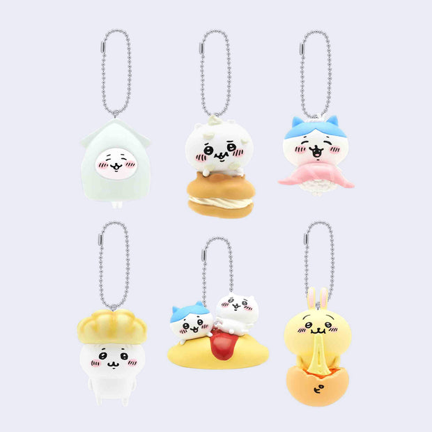 6 small key charms of small cute white cat creatures paired with food: a squid, cream puff, nigiri, gyoza, omelet and bun.