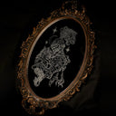 An ornate oval framed mirror, featuring a white line-drawn engraving of a figure, seen from the waist up, wearing a full set of armor and helmet. They hold a very fluffy cat. The mirror is set against a dark backdrop.