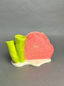 Ceramic sculpture of an under sea theme, with pink and green coral, a sea anemone, stones, fish and various other sea creatures.