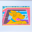 A risograph art print featuring a colorful cartoon dog peeking out of a pink car window, mounted on a white wall with a light wood frame and white mat.