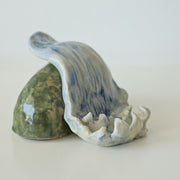 Ceramic sculpture of a waterfall over a rock.