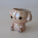 Shiny ceramic sculpture of a sitting cartoon bunny, with its head open and functional as a cup.