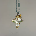 Small ceramic figure of a unicorn with a gold horn and gold detailings, attached to a keychain.