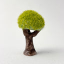 Ceramic tree with green grass flocking on the exterior of the tree top.