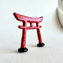 Small ceramic sculpture of a red Torii gate.