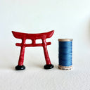 Small ceramic sculpture of a red Torii gate.