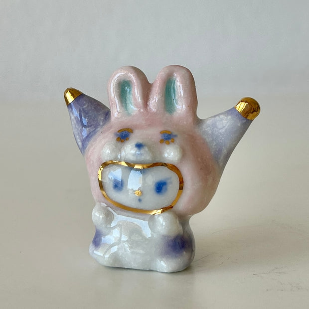 Ceramic rabbit figurine with gold accents on a plain background